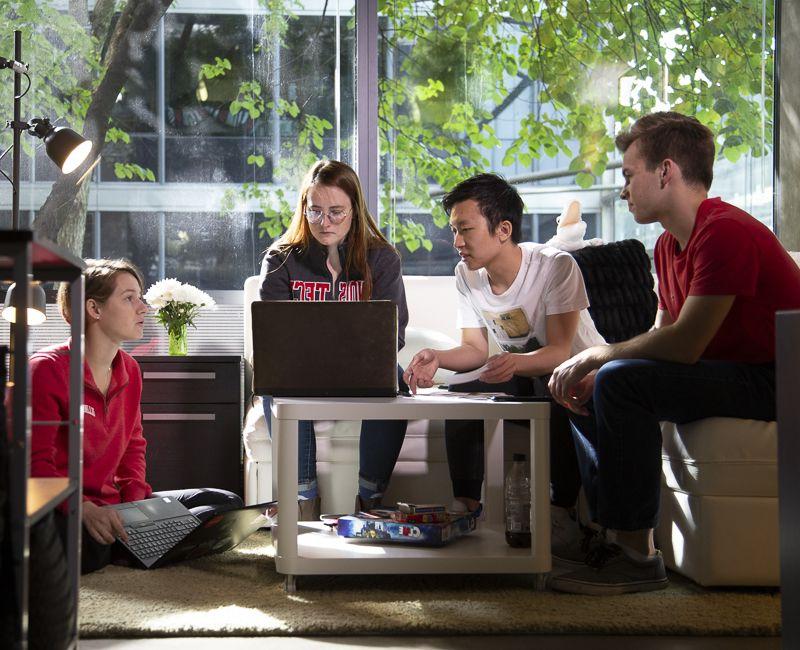 Students visit with an RA in Rowe village